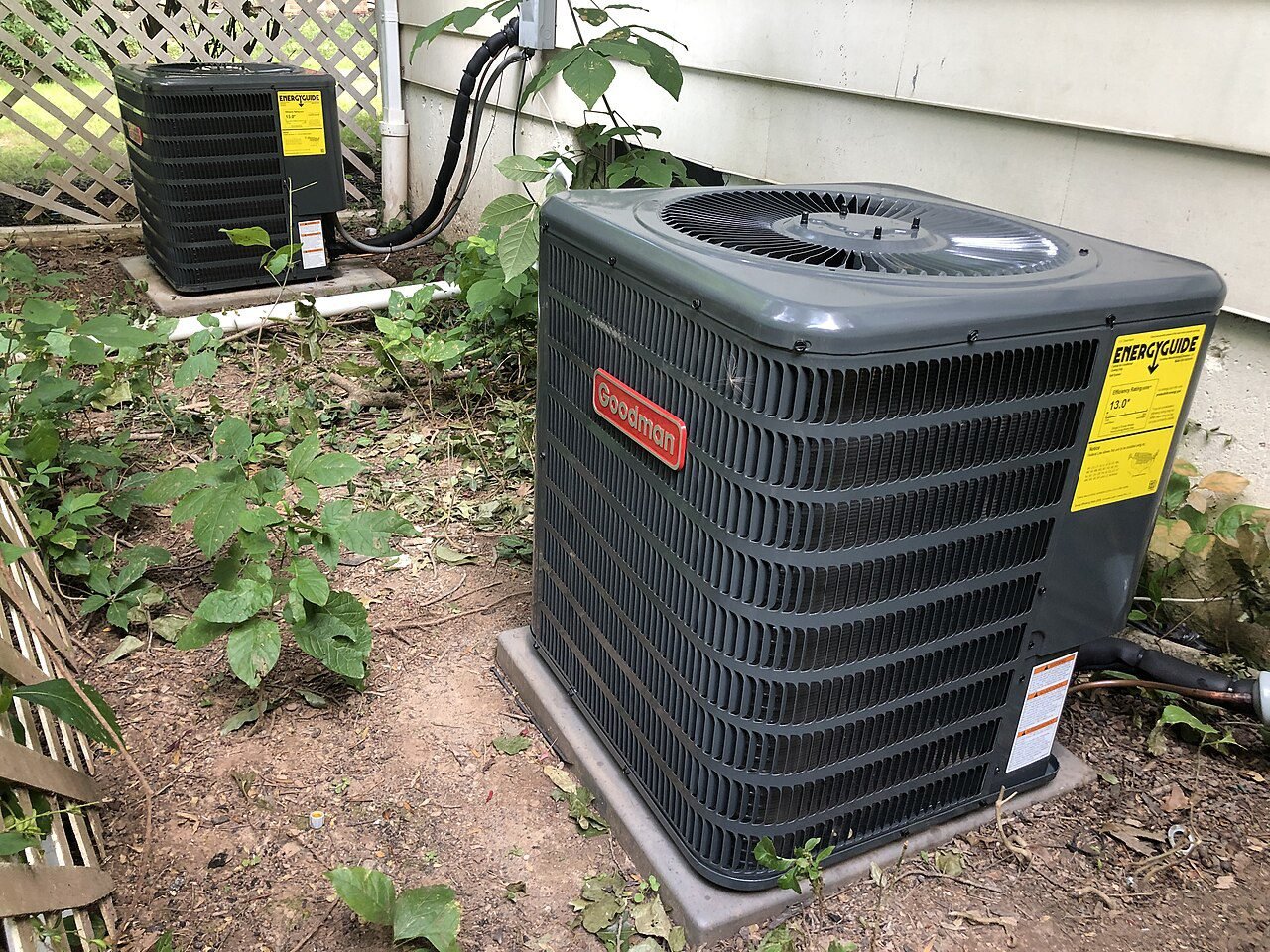 Air conditioning units beside a house in summer.
