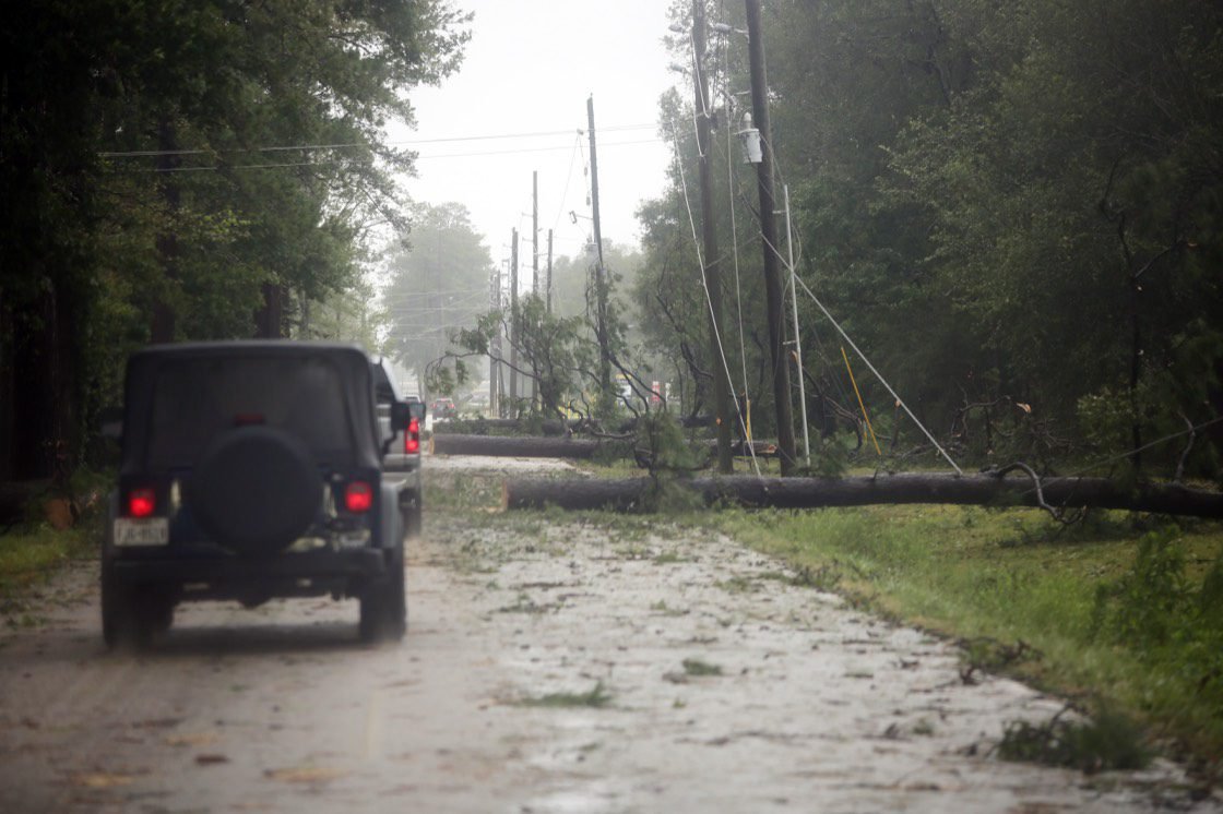 Downed power lines and a fallen tree blocking a road near New Caney, TX after Hurricane Beryl