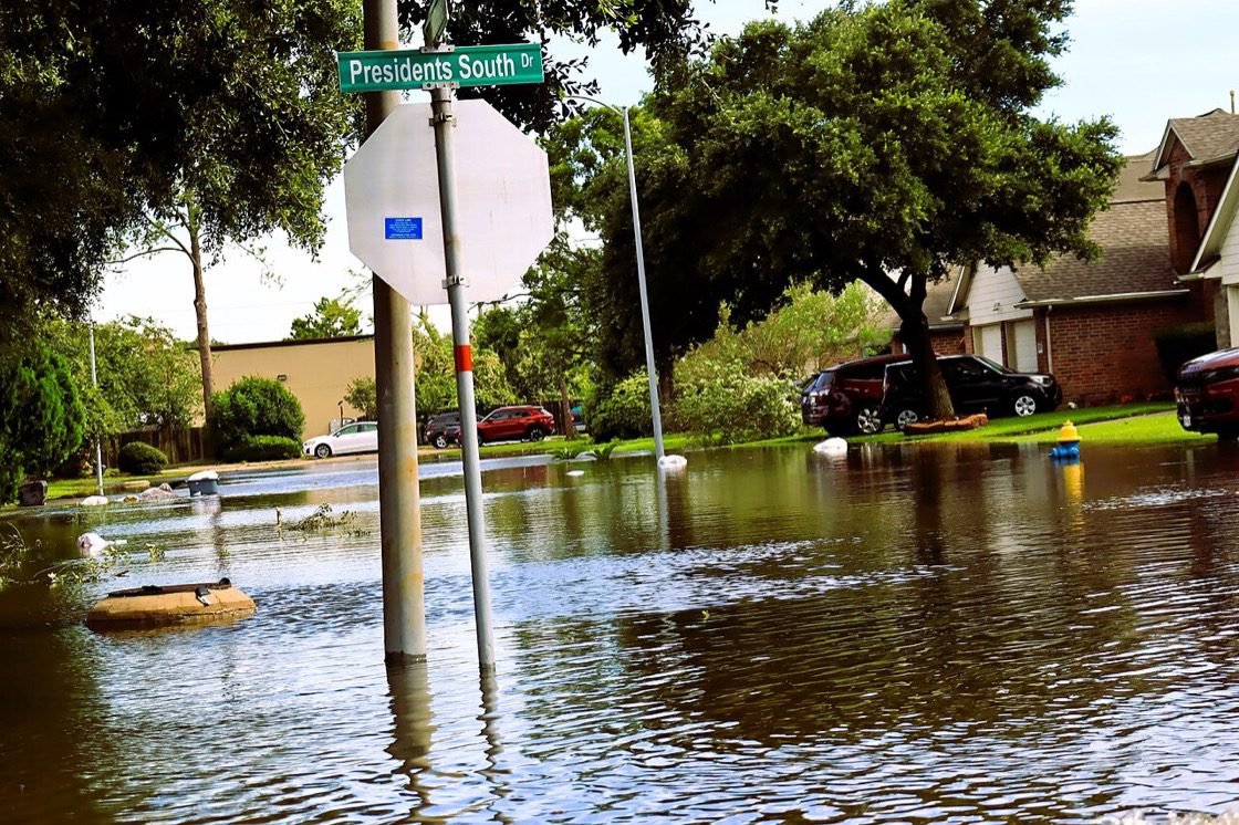 A flooded residential street with homes and driveways underwater, Morningside on the Park neighborhood, Houston, after Hurricane Beryl